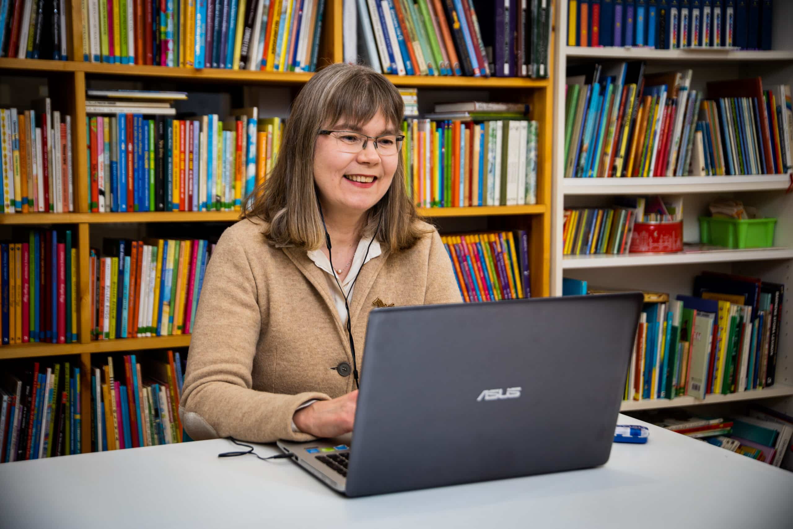 a woman sitting at a desk with a laptop